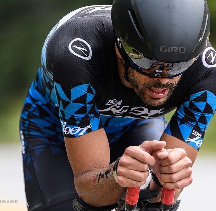 Breno Melo riding aero on his time-trial bike during an IRONMAN 70.3 bike leg