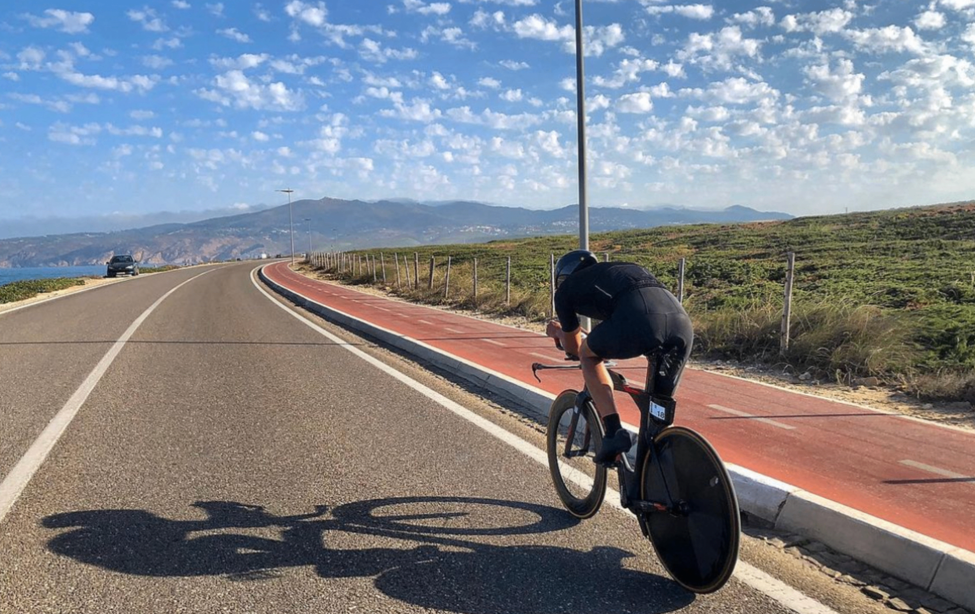 Breno Melo on a time-trial bike on a coastal Portuguese road during training camp